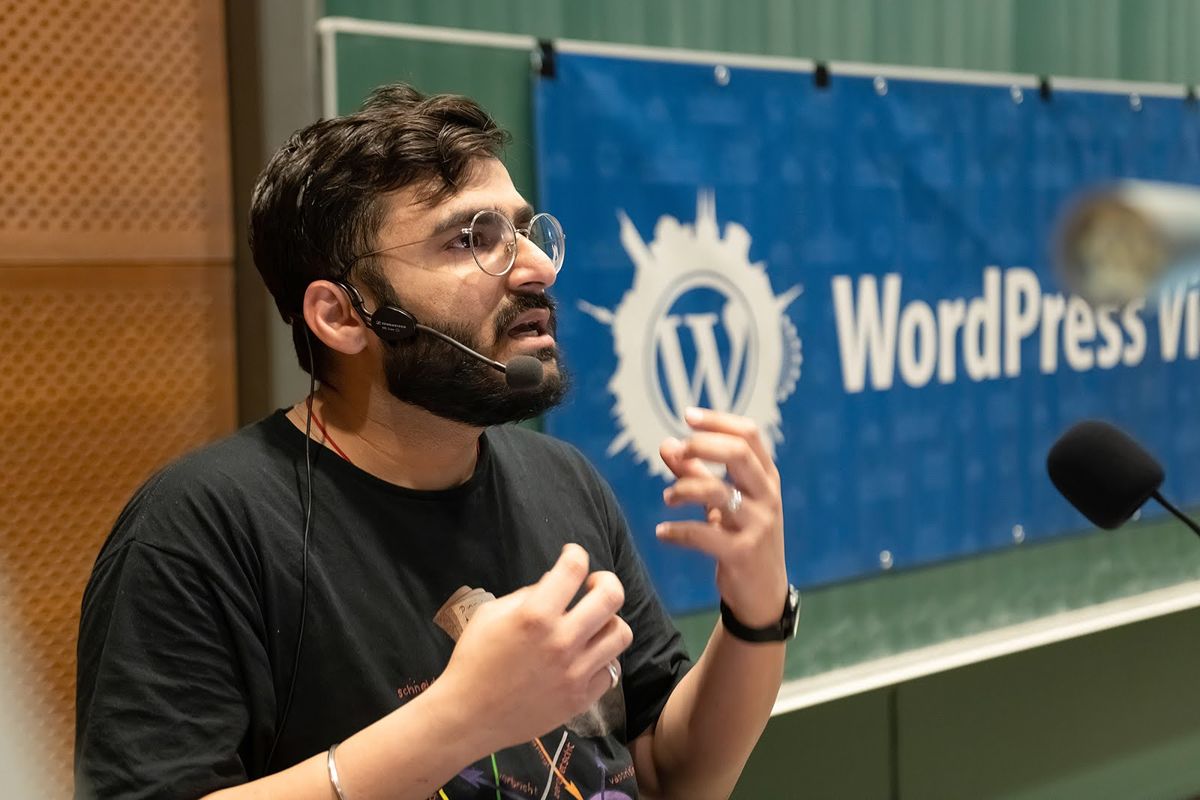 Vineet explaining something with both hands at WordCamp Vienna
